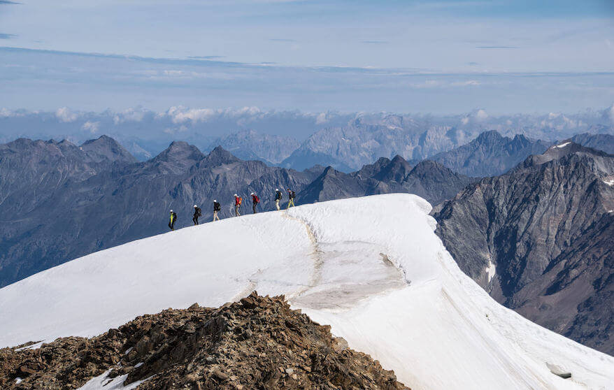 Seilschaft in einer Reihe in der Ferne vom Gipfel der Wildspitze aus gesehen