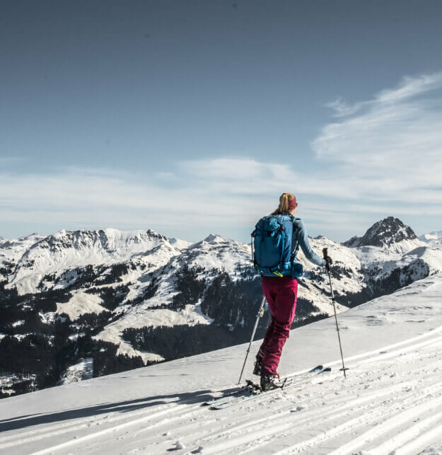 Frau beim Aufstieg zum Lodron im Winter mit Skitourenausrüstung.
